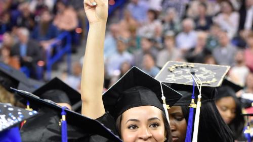 UMass Lowell graduate holds up peace sign at commencement