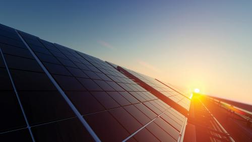 Stock image of a sunset behind a solar panel
