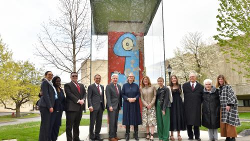 a segment of the Berlin wall that was donated to UMass Amherst. standing in front is president marty meehan, wife jennifer meehan and their two daughters Caroline and Ella.