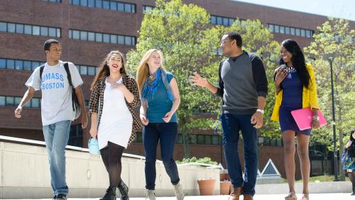 UMass Boston college students walking on campus, talking and interacting with each other..