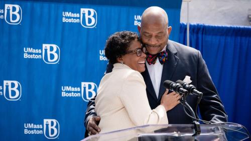 Dr. J. Keith and Angela Motley hugging each other on stage at UMass Boston.