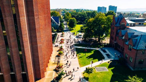 Drone photo of the UMass Amherst students walking around the du bois library on a sunny day. 