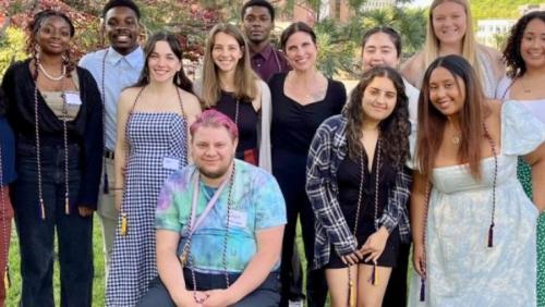 A group of UMass Amherst students standing outside on the campus.